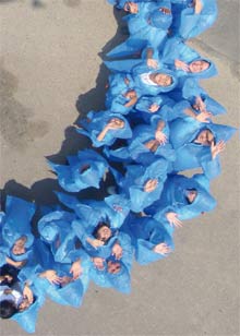 Menschen in blauen Regencapes im Kreis